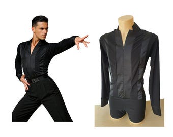 May include: Black dance shirt with long sleeves and a satin panel down the front. The shirt is paired with black trousers and a belt with a decorative buckle. The image also shows the shirt on a mannequin.