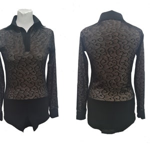 May include: Black bodysuit with long sleeves and a collared neckline. The sheer top has a swirling pattern. The bottom is solid black. The bodysuit is displayed on a mannequin.