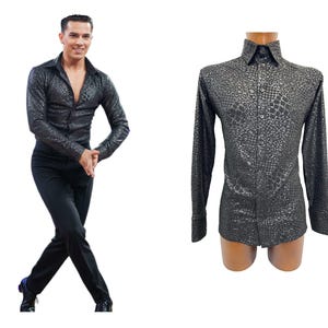 Può includere: Una camicia nera a maniche lunghe con un motivo strutturato, chiusura con bottoni e colletto classico. La camicia è esposta su un manichino ed è indossata anche da una persona con pantaloni neri. La camicia ha un aspetto lucido e strutturato.
