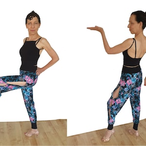 May include: A woman wearing a black tank top and floral print trousers with slits on the sides. She is standing with one leg raised and her hand on her hip. The other image shows the same woman with her arm extended, wearing the same outfit.