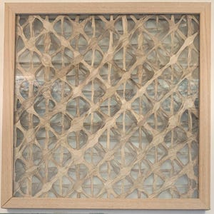 May include: A square wall art piece featuring a light-colored wooden frame enclosing a complex, three-dimensional lattice structure made of interwoven, tan-colored fibrous material that creates a repeating diamond-shaped grid pattern.