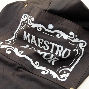May include: A brown leather jacket with a white patch that says "MAESTRO" in a decorative font.