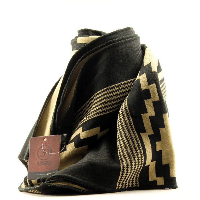May include: A black and beige patterned scarf with a brown tag that says "El Charro" and "www.elcharro.com".
