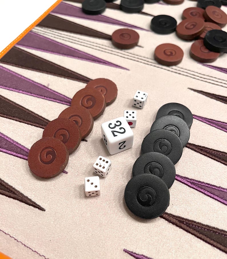 Backgammon dice and checkers displayed on the board’s suede surface. A quality backgammon game that makes an elegant and thoughtful gift.