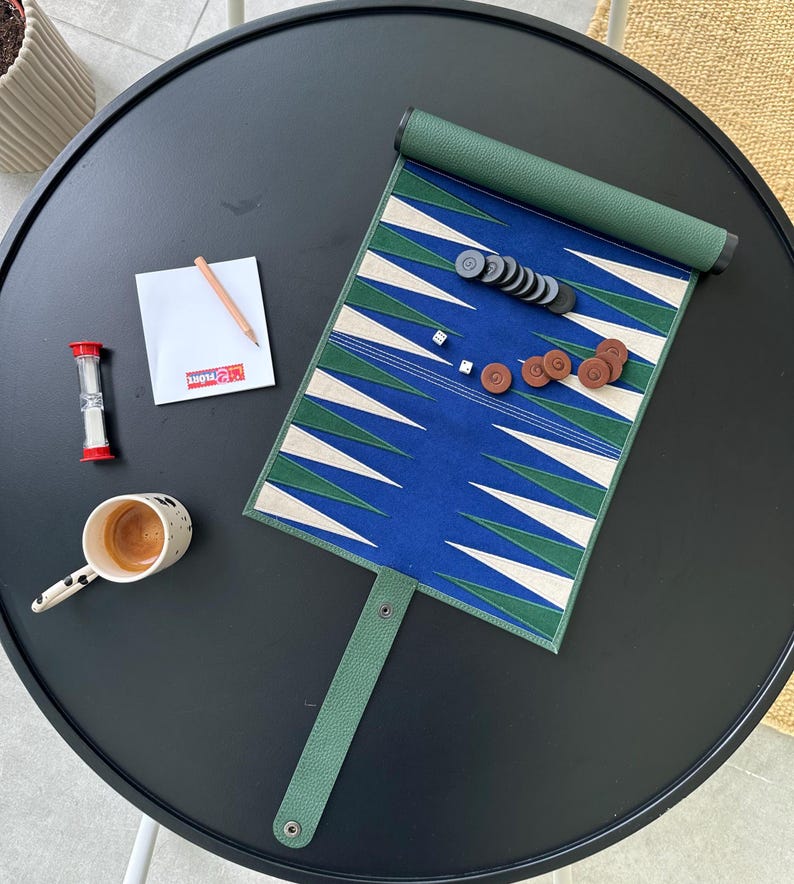 Open leather backgammon board with stitched triangles and checkers neatly placed, photographed on a rustic wooden surface. A quality boardgame ideal as a house present or luxury gift.