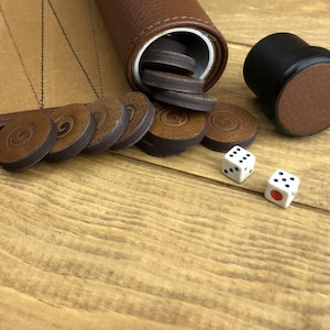 Backgammon dice and checkers displayed on the board’s suede surface. A quality backgammon game that makes an elegant and thoughtful gift.