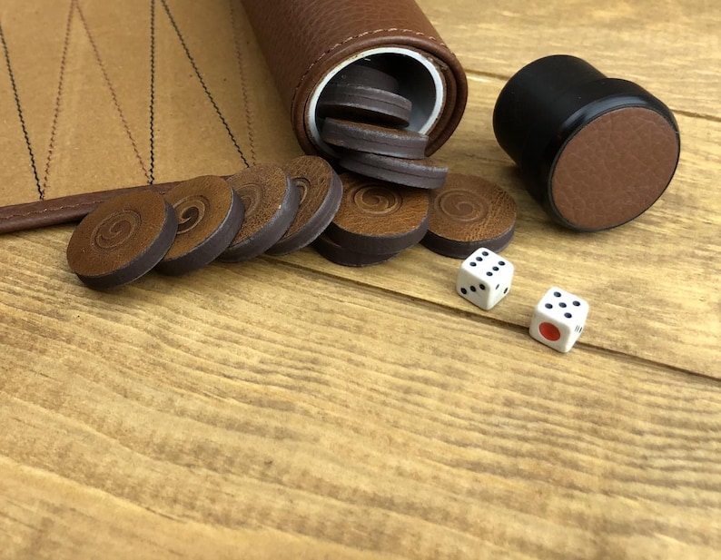Backgammon dice and checkers displayed on the board’s suede surface. A quality backgammon game that makes an elegant and thoughtful gift.