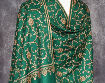 May include: A green shawl with intricate gold embroidery featuring a floral pattern. The shawl is made of a soft, luxurious fabric and is perfect for adding a touch of elegance to any outfit.