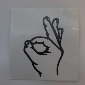 May include: Black and white line drawing of a hand making the OK sign.
