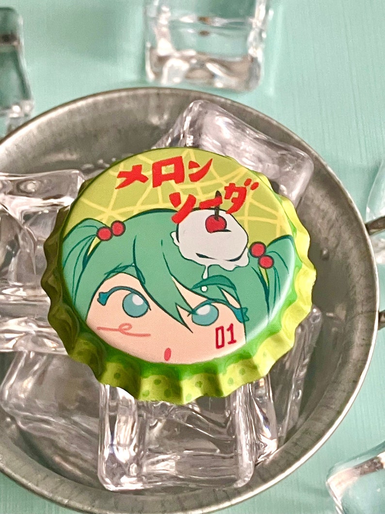 Puede incluir: Tapa de botella verde con un personaje de dibujos animados con cabello verde y una cereza en la parte superior. El texto en la tapa dice "メロンソーダ" y "01".