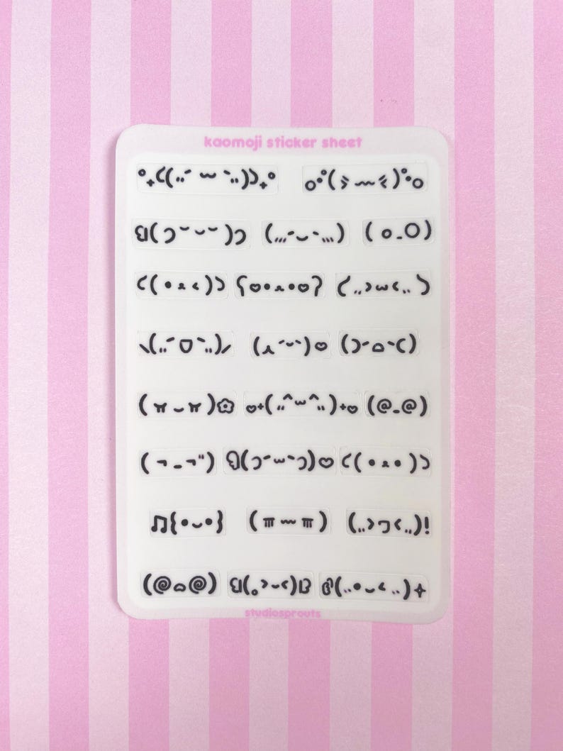 May include: A white sticker sheet with various kaomoji emoticons in black. The sheet has the text "kaomoji sticker sheet" at the top. The background is a pink and white striped pattern.