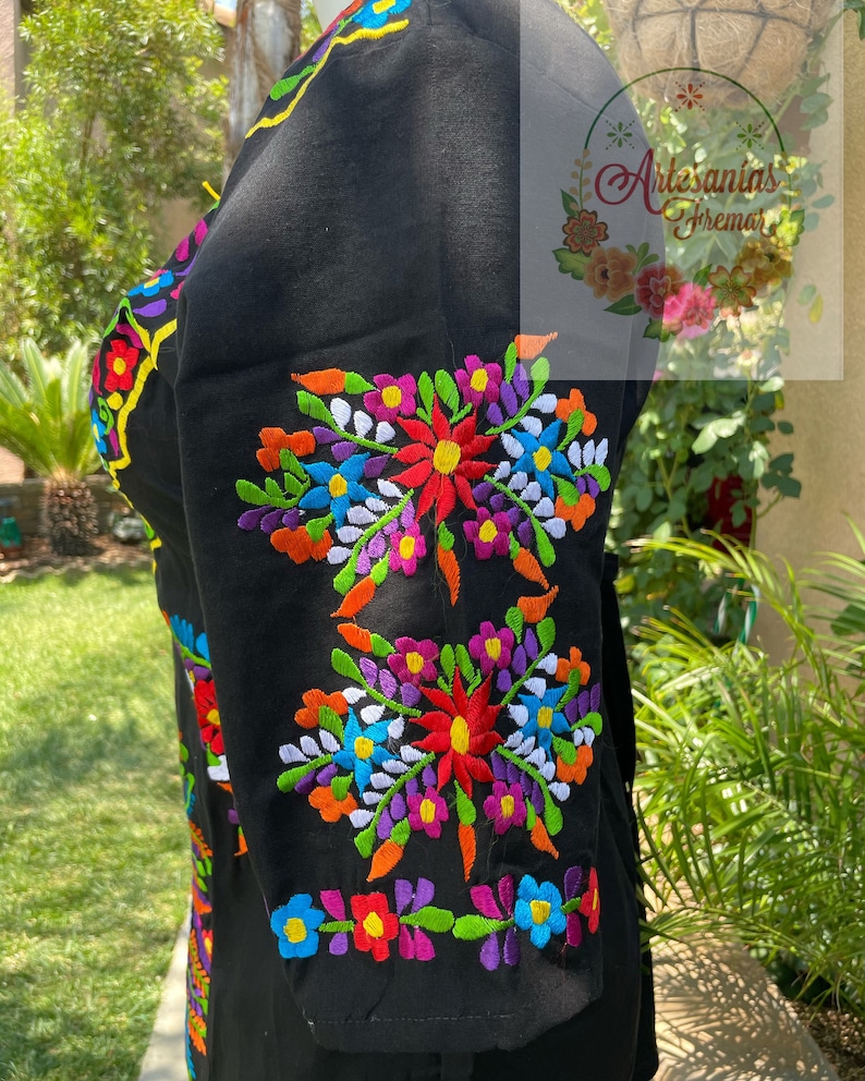 May include: Black embroidered blouse with colorful floral designs. The embroidery features a variety of colors, including red, orange, yellow, green, blue, purple, and white.