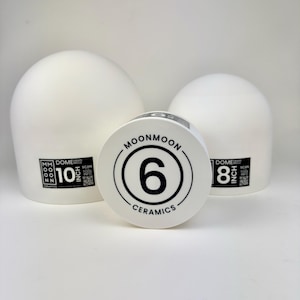 May include: Three white ceramic dome drape molds of varying sizes. The largest mold is labeled 10 inch, the middle mold is labeled 6, and the smallest is labeled 8 inch. Each mold features the Moonmoon Ceramics logo and a QR code for tool info.