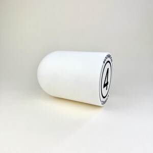 Op de afbeelding: Een wit keramisch object met afgeronde uiteinden. Het object heeft een zwart cirkelvormig logo met het nummer 4 erin en de woorden "MOONMOON CERAMICS" rond de cirkel. Het object staat op een witte achtergrond.