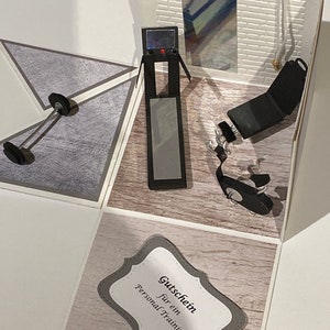 May include: A handmade papercraft gym scene with a treadmill, weight bench, and dumbbell. The interior features a mirror and a brick wall. A gift certificate with the text "Personal Training" is also included.
