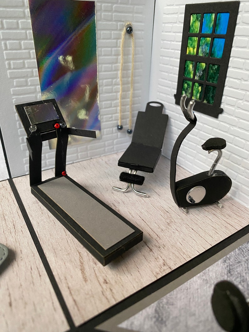 May include: A miniature gym scene featuring a treadmill, exercise bike, and weight bench. The room has white brick walls, a window, and a rope hanging from the ceiling. The treadmill has a grey running surface and a black frame.