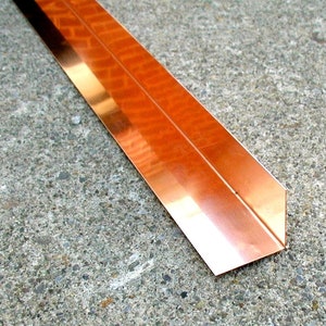 May include: A copper corner molding strip, a metal trim piece for finishing corners of walls or ceilings.