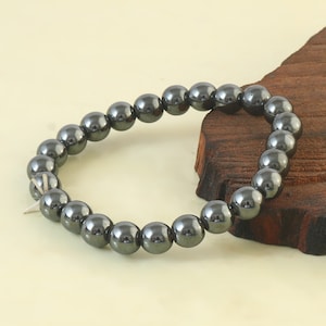 May include: A black hematite beaded bracelet with round beads.