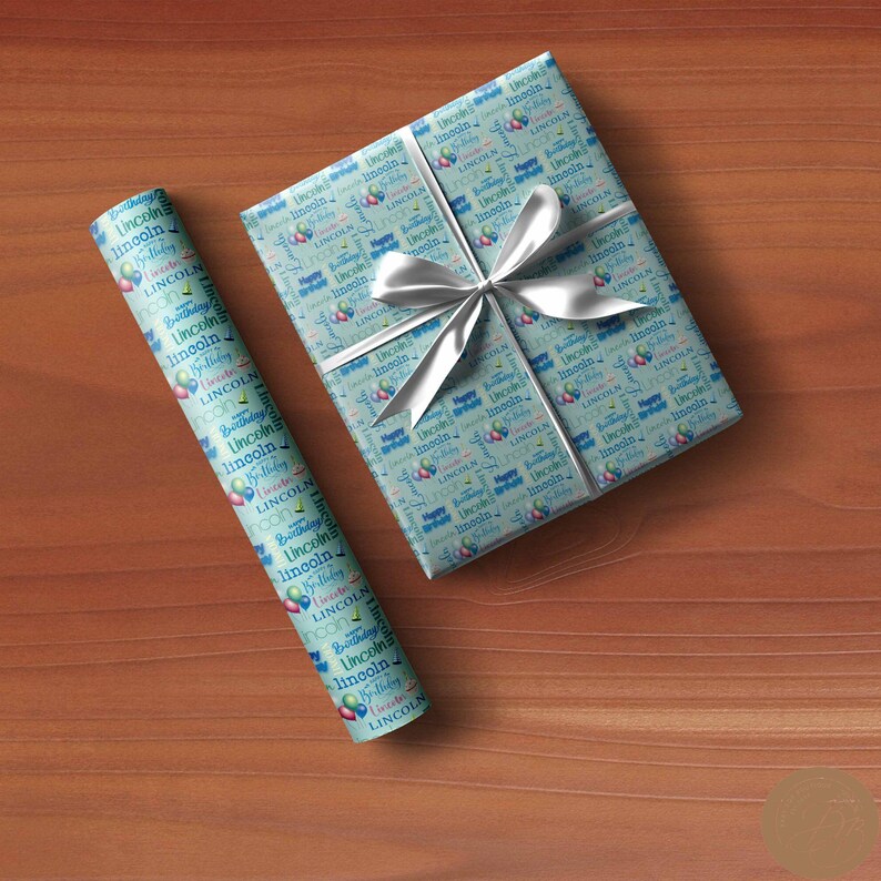 May include: Blue and white wrapping paper with a repeating pattern of balloons and the name "Lincoln" printed on it. The paper is rolled up and tied with a white ribbon.