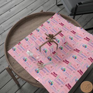 May include: Pink wrapping paper with a repeating pattern of balloons, cake slices, and the name "Linsey" in various fonts and colors. The text "Happy Birthday" is also repeated throughout the pattern.