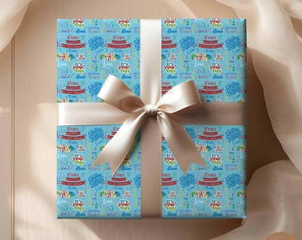 May include: Blue wrapping paper with a colorful birthday pattern. The paper features the name "Evan" and the phrase "It's your day" repeated throughout. A beige satin ribbon is tied around the paper.