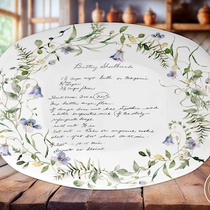 May include: White oval serving platter with a floral design and a handwritten recipe for Buttery Shortbread. The recipe includes ingredients like butter, flour, and sugar, and instructions for baking the shortbread.