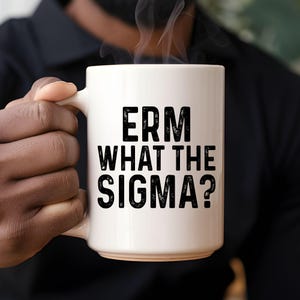 Puede incluir: Taza de café de cerámica blanca con texto negro que dice "ERM WHAT THE SIGMA?"