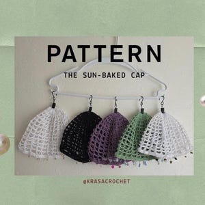 May include: Five crocheted caps in white, black, purple, and green hanging from a white plastic hanger. The text reads PATTERN THE SUN-BAKED CAP and @KRASACROCHET. Each cap features an openwork mesh design with small beads along the bottom edge.