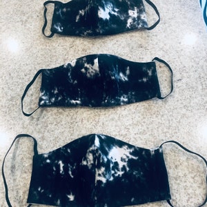 May include: Three black and white tie-dye face masks with elastic ear loops.