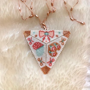 May include: A triangular beaded necklace with a pink bow, flowers, and butterflies. The necklace is made of white, pink, and green beads and has a rose gold chain.