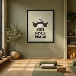 K&ouml;nnte beinhalten: Ein gerahmter Druck mit einem Cartoon-Panda in einer Yoga-Pose mit den Worten "INNER PEACE" in fetten, schwarzen Buchstaben. Der Panda hat einen wei&szlig;en Bauch, braune Arme und einen schwarz-wei&szlig;en Kopf. Der Druck befindet sich in einem Raum mit Yogamatten und einer Topfpflanze.