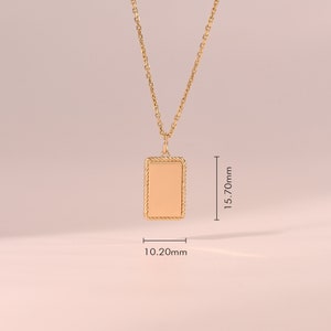 May include: A gold-toned necklace featuring a rectangular pendant with a rope-style border. The pendant measures 15.70mm in height and 10.20mm in width. The chain is a delicate link style, and the entire piece has a smooth, polished finish.