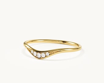 May include: A yellow gold curved band ring featuring five small round clear stones set along the center dip. The metal has a polished finish and a smooth, thin shank. The interior of the band is clearly stamped with the text 14K.