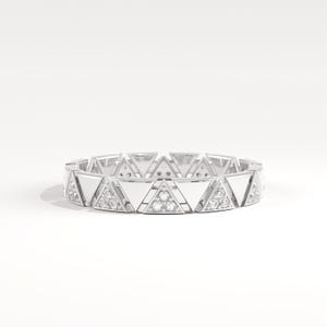 May include: A silver ring with a repeating triangular design. Each triangle alternates between a smooth, reflective surface and a section with small, sparkling gemstones. The ring is set against a white background.