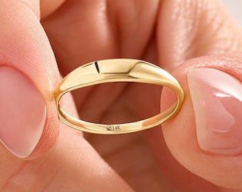 Op de afbeelding: Een gepolijste 14K geelgouden ring met een glad, koepelvormig oppervlak. De binnenkant van de ring is duidelijk gestempeld met de tekst 14K, wat de zuiverheid van het goud aangeeft. De ring heeft een eenvoudig, massief metalen ontwerp.