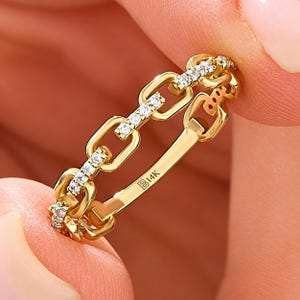 May include: A 14K gold chain link ring featuring alternating polished gold links and links encrusted with small clear white stones. The interior of the band is clearly stamped with the text B14K, indicating the gold purity of the jewellery piece.