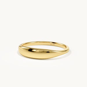 May include: A polished 14K yellow gold ring featuring a smooth, curved, solid band design. The metal surface is highly reflective and uniform in color. The interior of the band is clearly stamped with the text 14K, indicating the gold purity.