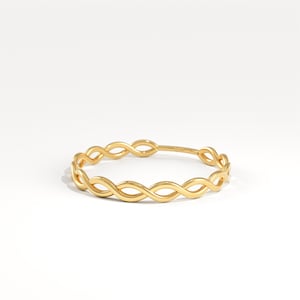 May include: A gold-coloured bangle bracelet featuring an infinity symbol design. The bracelet is made of a shiny, smooth metal and has a continuous pattern of intertwined loops. The bracelet is a simple yet elegant piece of jewellery.