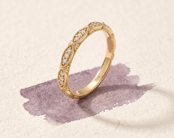 May include: A gold ring featuring a series of marquise-shaped settings, each containing three small round clear stones. The band has a beaded edge and a stamped 14K mark on the inner surface, showcasing a detailed metalwork design.