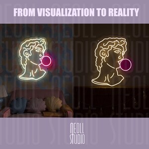 May include: A neon sign featuring the profile of a classical marble bust with curly hair, blowing a bright pink bubble. The sign displays the text FROM VISUALIZATION TO REALITY at the top and NEOLL STUDIO at the bottom in a clean, sans-serif font.