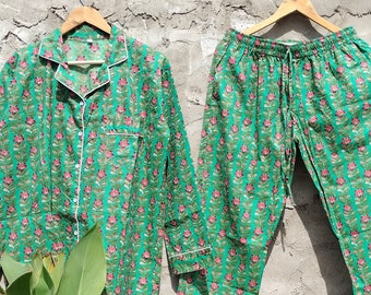 May include: A green and pink floral print pyjama set with a button-up top and matching trousers.