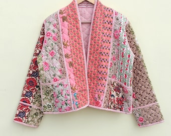 Puede incluir: Una chaqueta acolchada rosa y blanca con estampado floral. La chaqueta tiene manga larga y cuello en V.