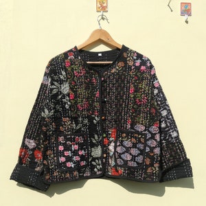 Pode incluir: Uma jaqueta acolchoada preta com estampa floral. A jaqueta tem fecho de botão e dois bolsos.