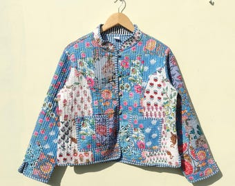 May include: A blue quilted jacket with a floral print. The jacket has a mandarin collar and a button closure. The sleeves are long and the jacket is lined with a white fabric.
