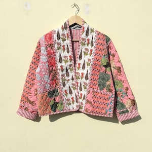 Könnte beinhalten: Eine rosafarbene gesteppte Jacke mit einem floralen und tierischen Muster. Die Jacke hat einen Kragen und lange Ärmel.