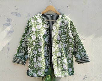 May include: A green and white floral print quilted jacket with a striped lining and trim. The jacket has two front pockets and is displayed on a wooden hanger. The jacket is a lightweight, open-front design.