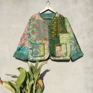 May include: A green quilted jacket with a patchwork design. The jacket has a button closure and two pockets.