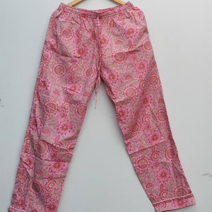 May include: Pink cotton pajama pants with a floral print. The pants have an elastic waistband and a drawstring.