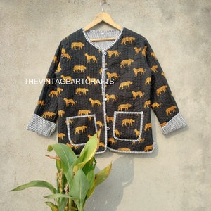 May include: A black quilted jacket with a white and black striped lining. The jacket has a button closure and two pockets. The fabric features a repeating pattern of orange tigers on a black background.