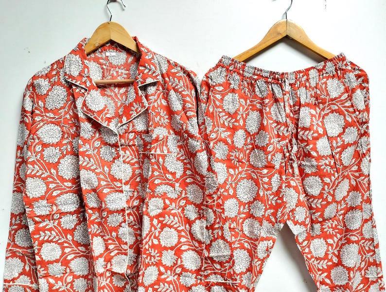 Puede incluir: Un conjunto de pijama de estampado floral rojo y blanco con mangas largas y pantalones.